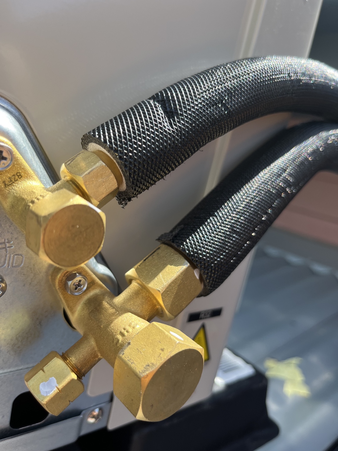 Black UV-rated insulated pair coil connected to an air conditioner