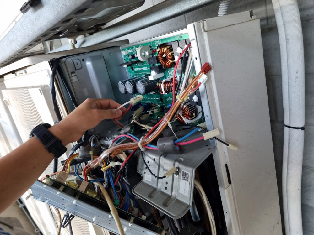 Swind technician checking residential air conditioner control components